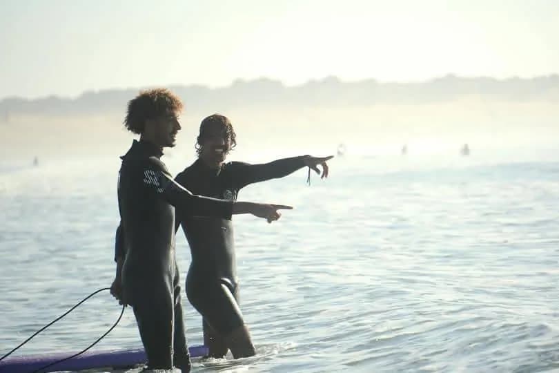 Two surfers in wetsuits spotting waves during Essaouira surf session